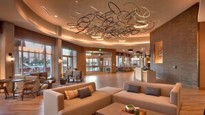 Eine geräumige Lobby mit gewölbter Decke, großen Fenstern und einer Rezeption.