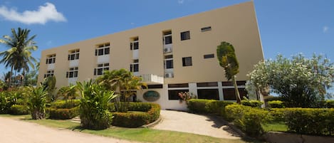 A modern building with a flat facade, multiple windows, and a sign indicating it is a hotel.