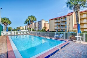 A swimming pool with a tiled edge, surrounded by a brick deck. - Oceanfront Condo with Spacious Patio and Private Walkway to the Beach by RedAwning (Fernandina Beach)