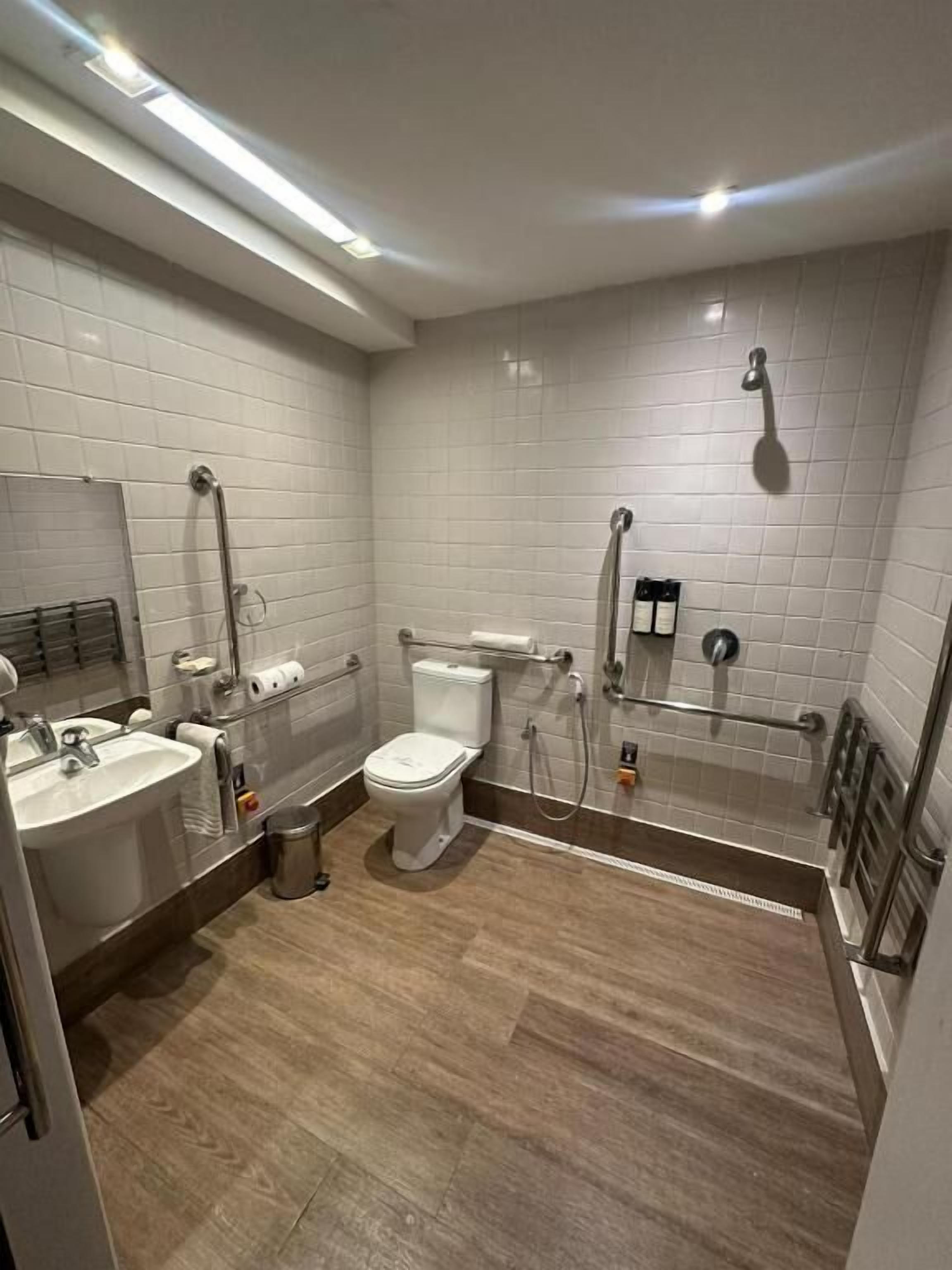 A modern bathroom with a toilet, sink, and shower.