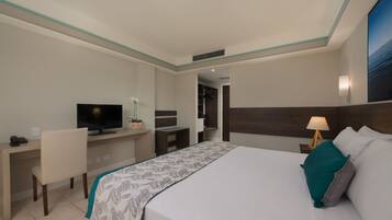 Una habitación de hotel con cama, escritorio, televisión y mesita de noche.