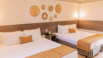 A hotel room with two beds, a wooden headboard, a wall-mounted light, and woven wall art.