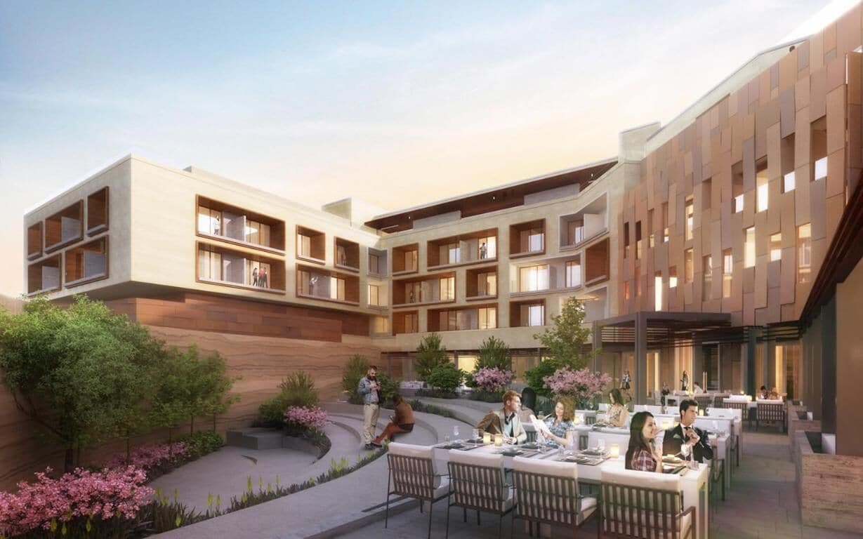 A modern hotel with multiple floors, outdoor dining area, and landscaped garden.