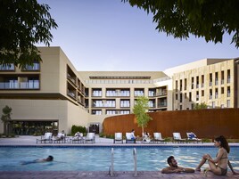 Una piscina al aire libre, sillones reclinables de piscina