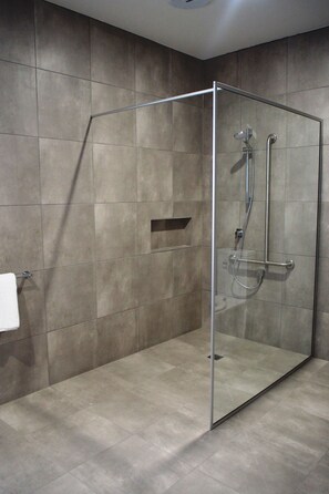 A modern bathroom with a glass-enclosed shower, tiled walls, and a visible towel rack. - Euston Motel (Euston)