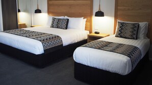 A hotel room with two beds, wooden headboards, and bedside lamps. - Euston Motel (Euston)