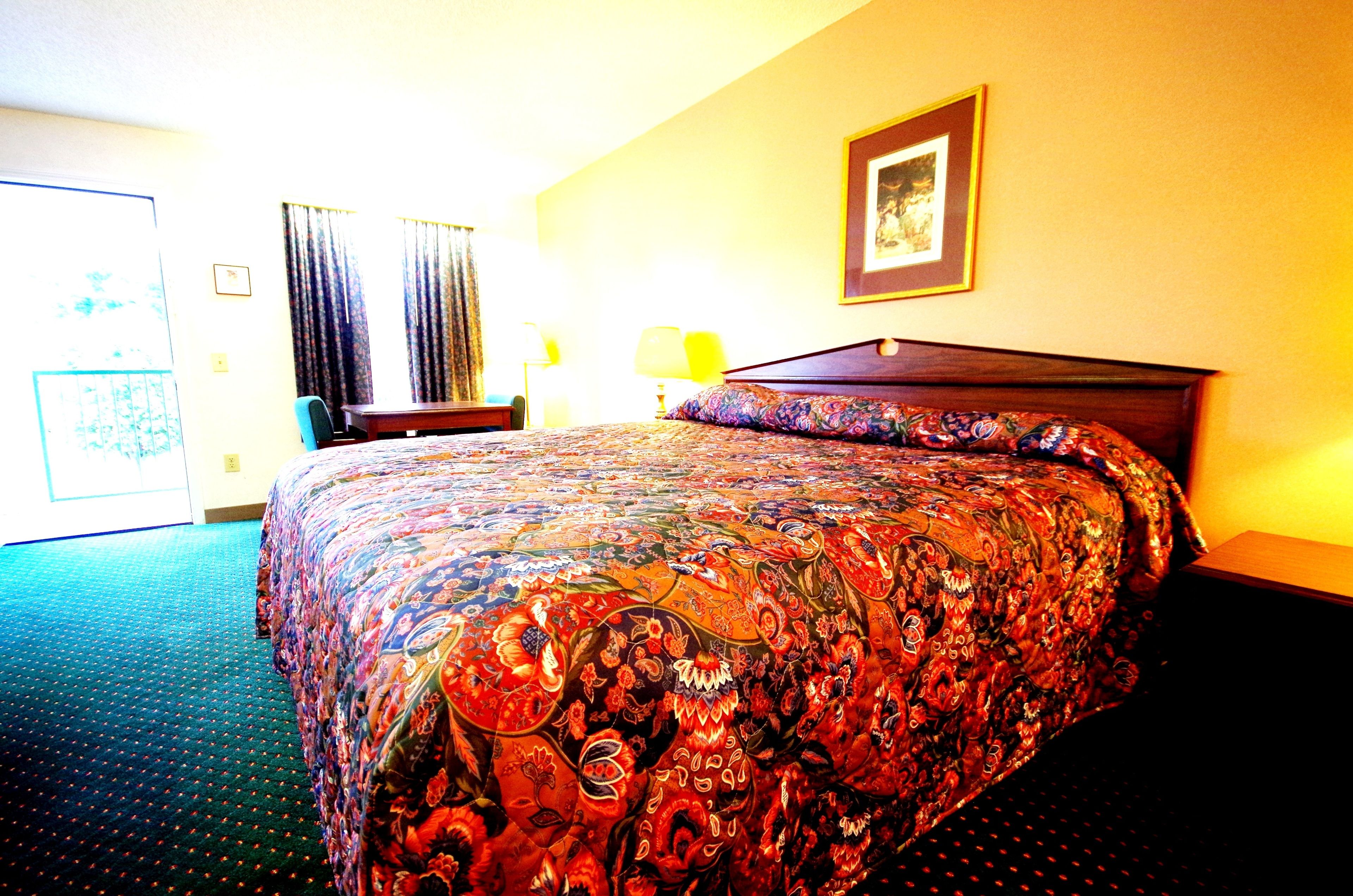 Ein Hotelzimmer mit einem großen Bett, einem Schreibtisch und einem Stuhl.