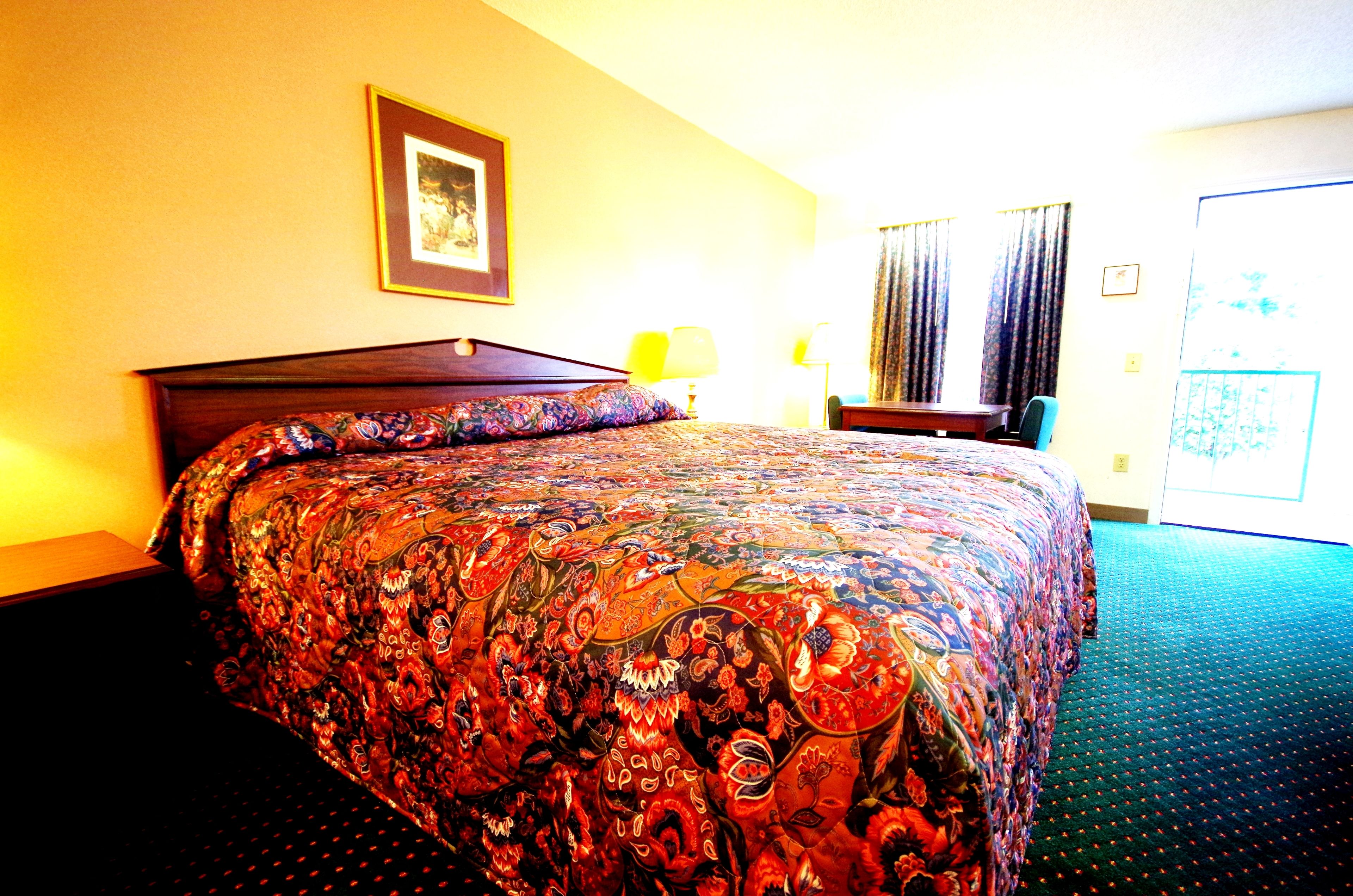 Una habitación de hotel con una cama grande, un escritorio y una silla.