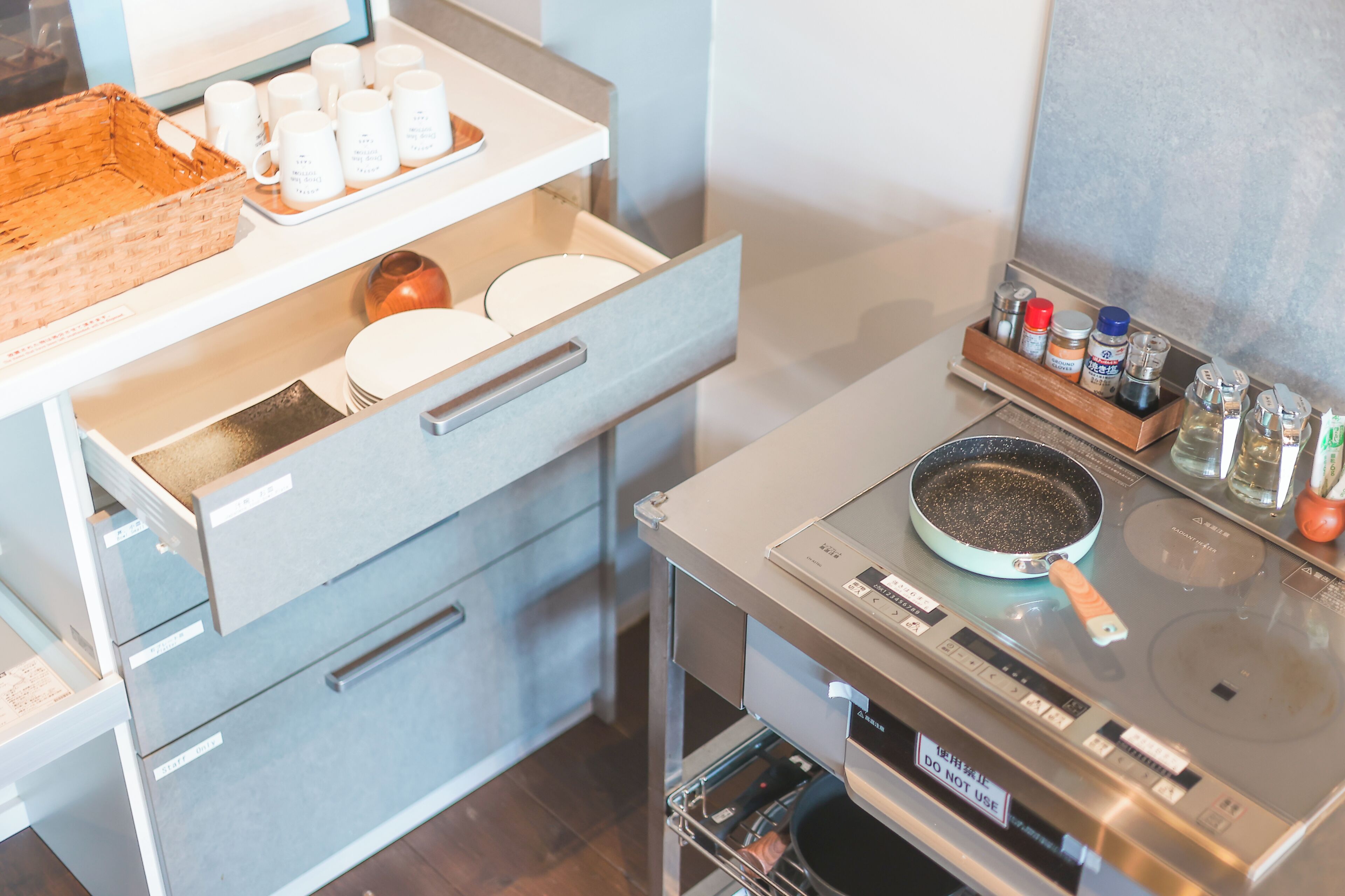 Una cocina con microondas, sartén y diferentes utensilios de cocina.