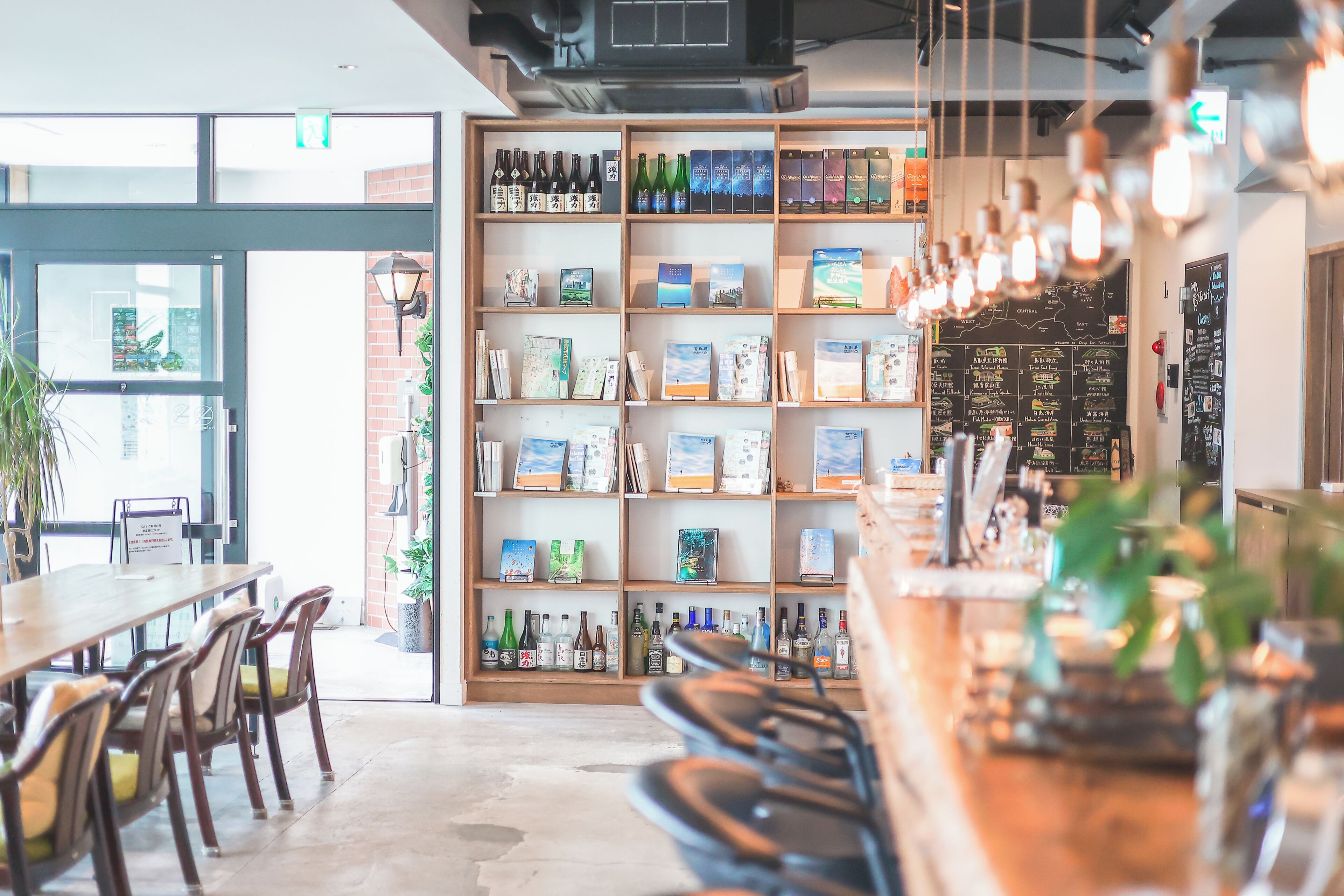 A bar area with shelves of bottles and a menu board.