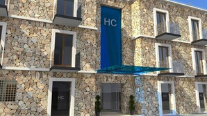A hotel facade with a stone exterior, multiple balconies, and a prominent 'HC' sign. - Hotel Catedral (La Paz)