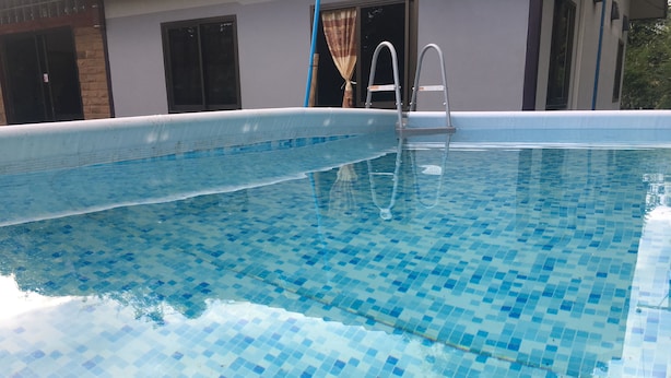 A swimming pool with a tiled floor and a ladder. - Pakasan Garden Home (Khon San)