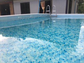 A swimming pool with a tiled floor and a ladder. - Pakasan Garden Home (Khon San)