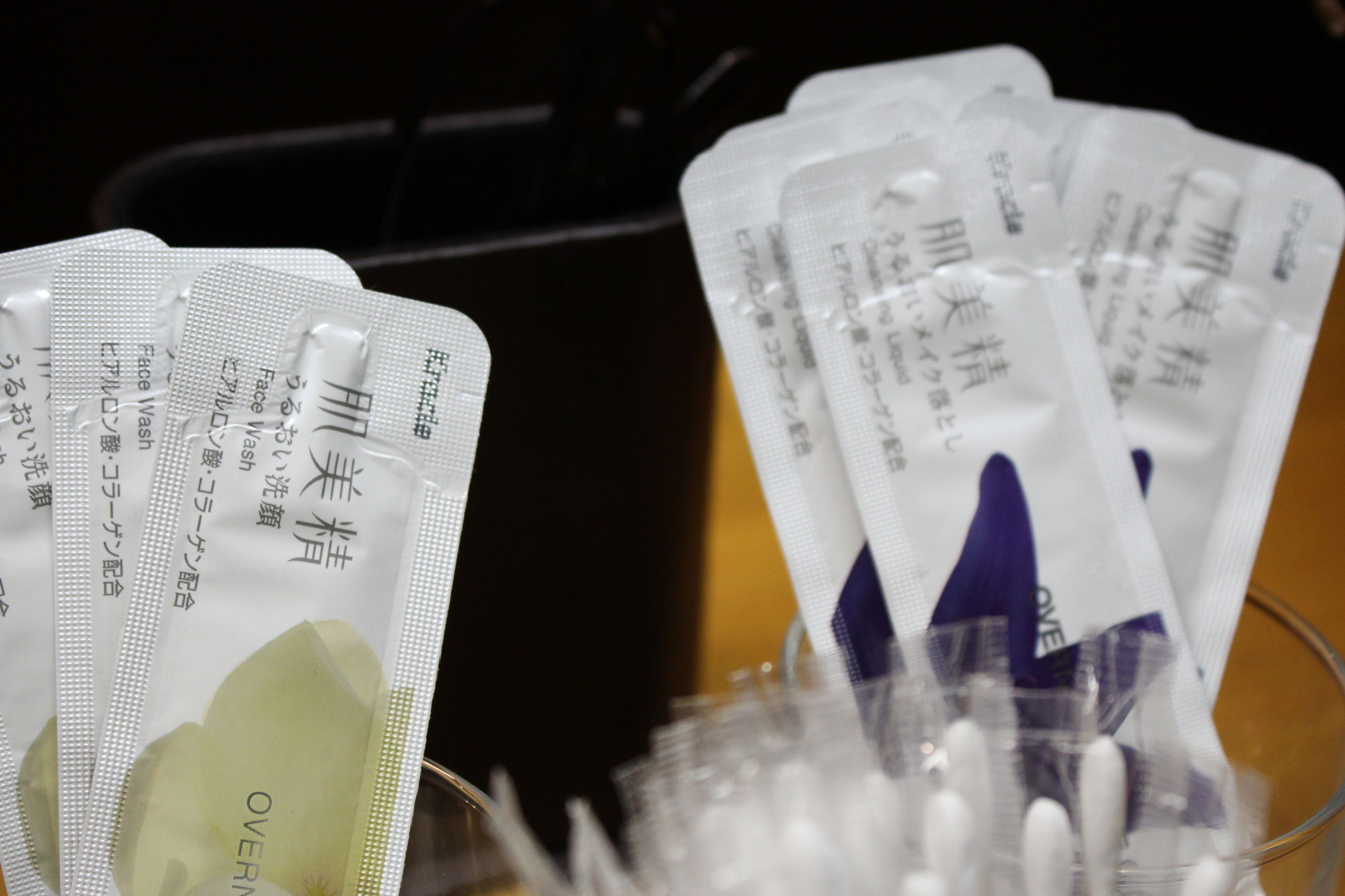 Several packets of facial wipes in a glass container.