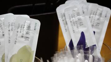 Several packets of facial wipes in a glass container.
