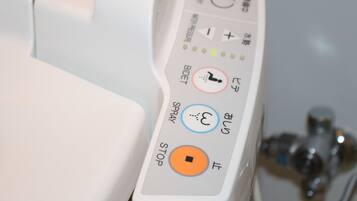 A control panel with buttons labeled "BIDET," "SPRAY," "STOP," and "OPEN."