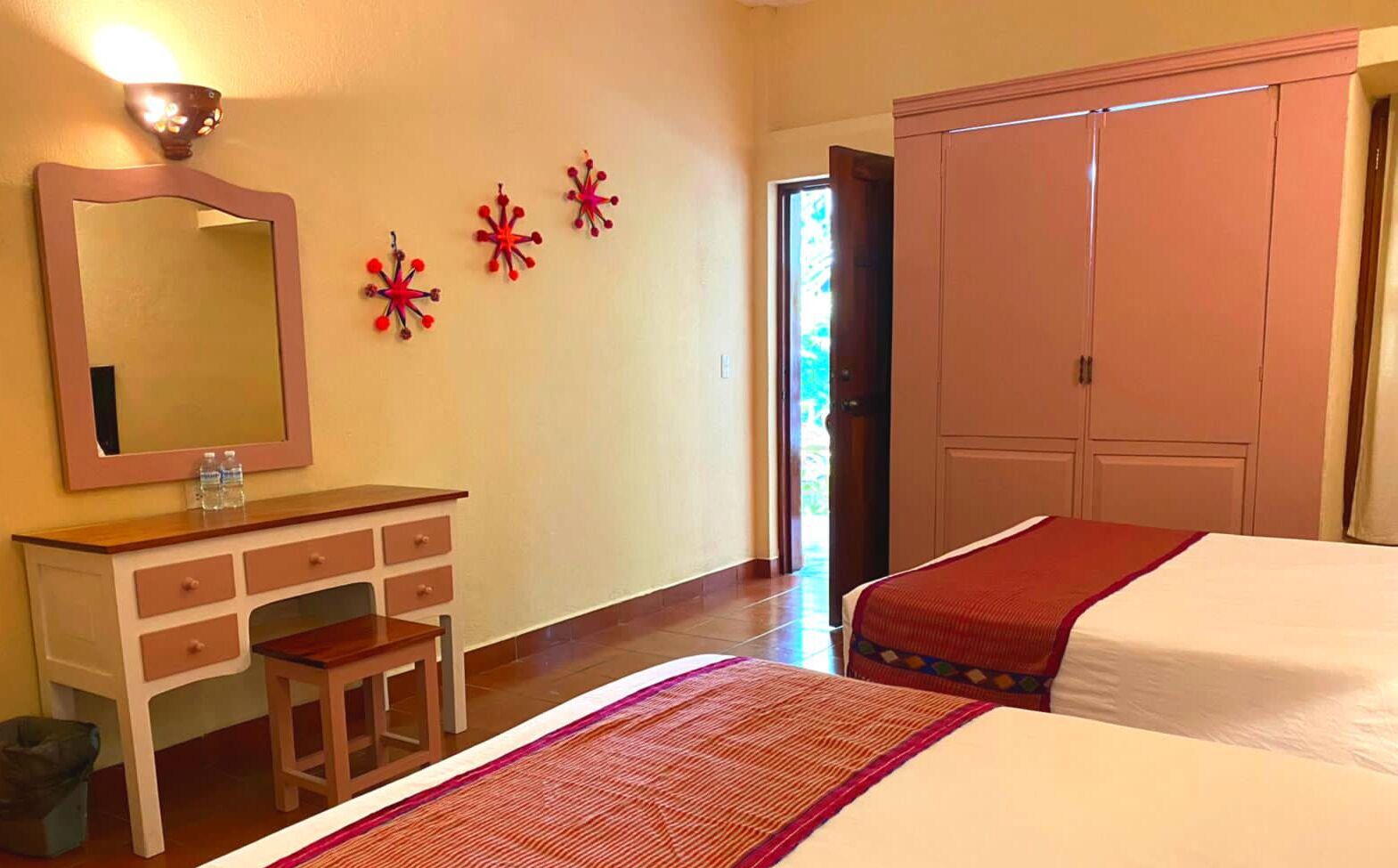 Een hotelkamer met een bed, een dressoir, een spiegel en een kledingkast.