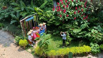A garden with a variety of plants and a sign for Hotel La Ceiba.