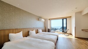 Una habitación de hotel con dos camas, un ventanal grande y vistas a la ciudad.