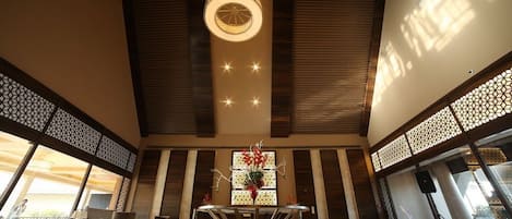 A spacious lobby with a central table, seating area, and a decorative light fixture.