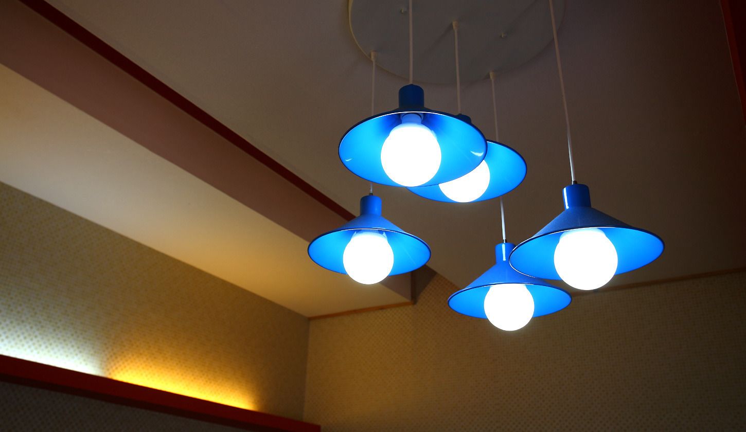 Eine Decke mit drei blauen Pendelleuchten.