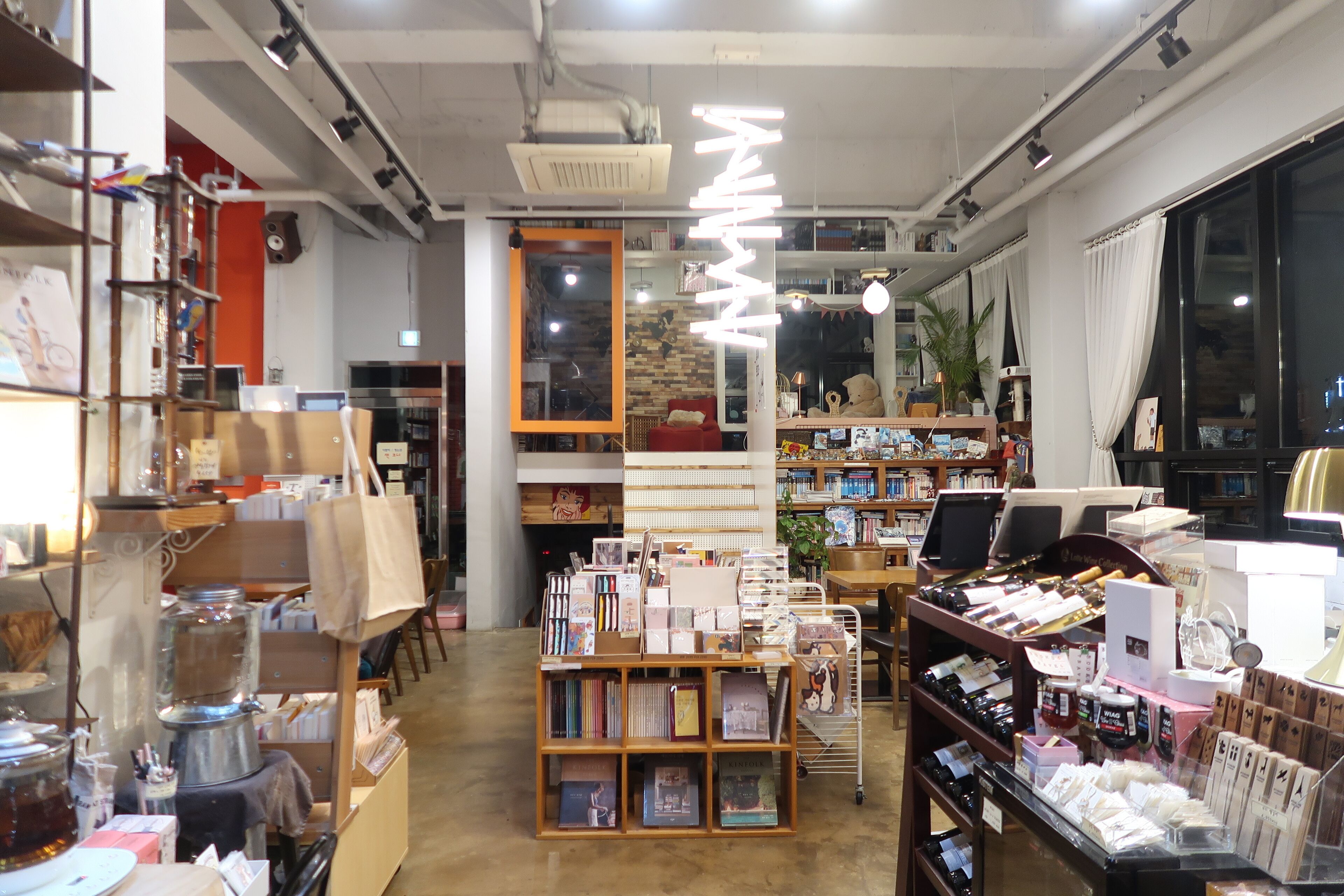A bookstore with shelves of books, a coffee machine, and a variety of items on display.