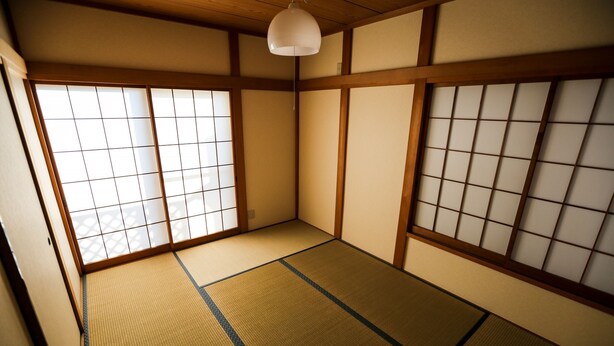 A traditional Japanese room with tatami flooring, shoji screens, and a hanging light fixture. - J's BackPackers Guest House - Hostel (Tokyo)