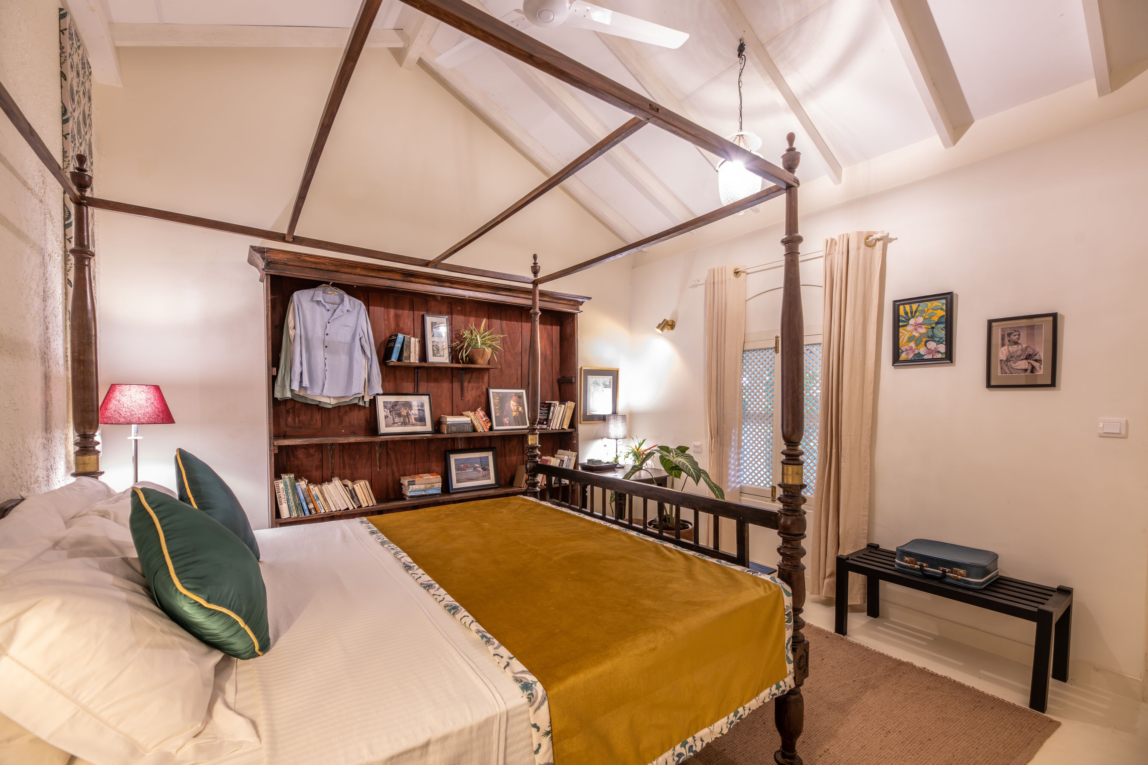 A four-poster bed with a green pillow, a wooden headboard, and a yellow bedspread.