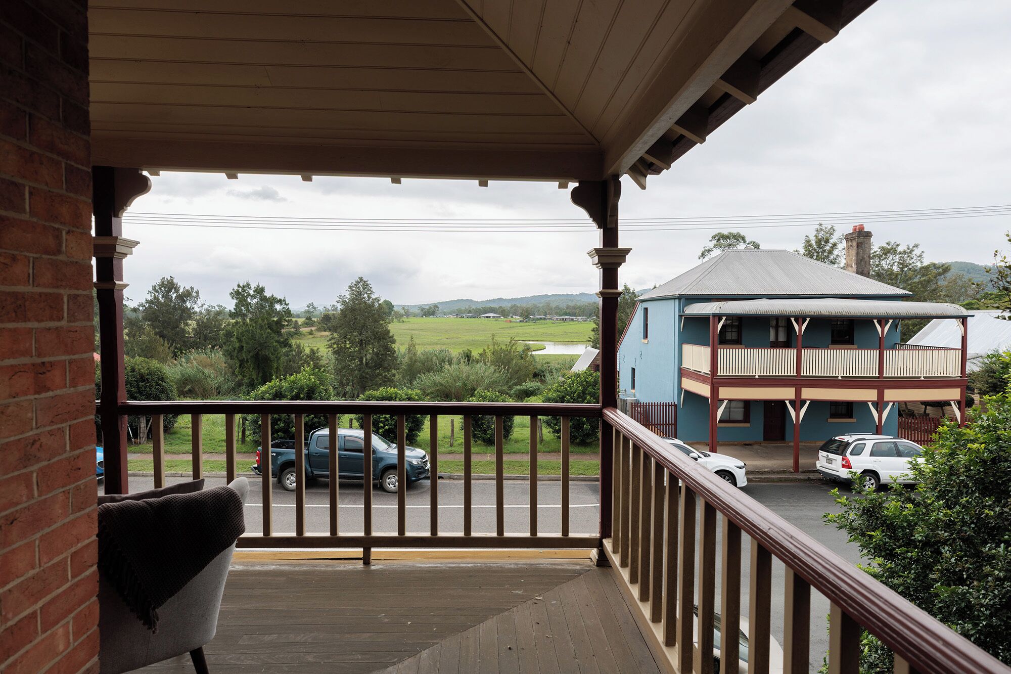 A balcony with a view of a road and a building across it.