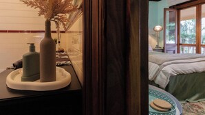 A bathroom with a sink, a bottle of hand soap, and a decorative vase with dried flowers. - Kings and Queens Paterson (Paterson)