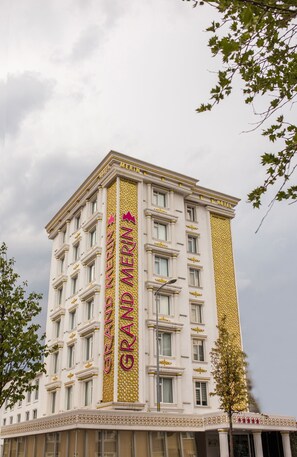 A multi-story hotel with a prominent vertical sign reading "GRAND MERIN HOTEL" and a gold decorative pattern on the facade. - Grand Merin Airport Hotel (Istanbul)