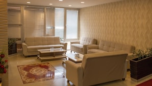 A modern living room with a beige sofa set, a coffee table, and a patterned rug. - Grand Merin Airport Hotel (Istanbul)