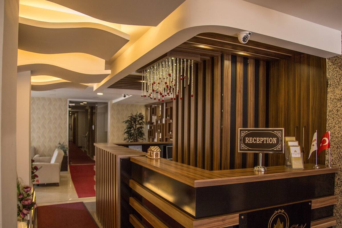 A reception desk with a sign reading "RECEPTION" and "GRAND MERIN HOTEL" in the lobby area.