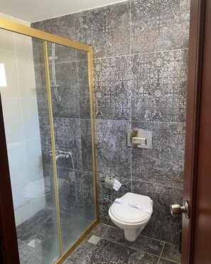 A bathroom with a shower, toilet, and a glass-enclosed shower area. - Grand Merin Airport Hotel (Istanbul)