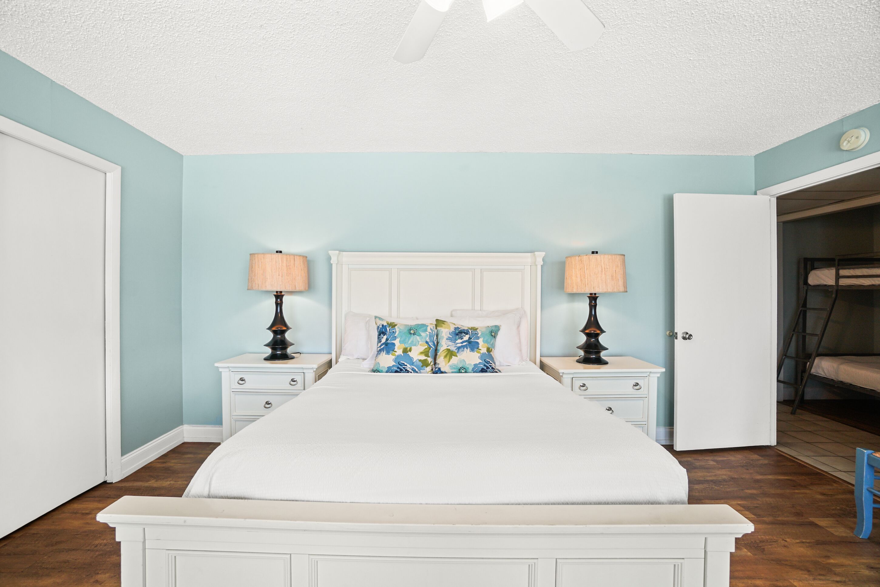 A bedroom with a bed, nightstands, and a door to a closet.