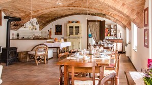 Un coin repas au style rustique, avec un plafond en briques, des meubles en bois et un poêle traditionnel.