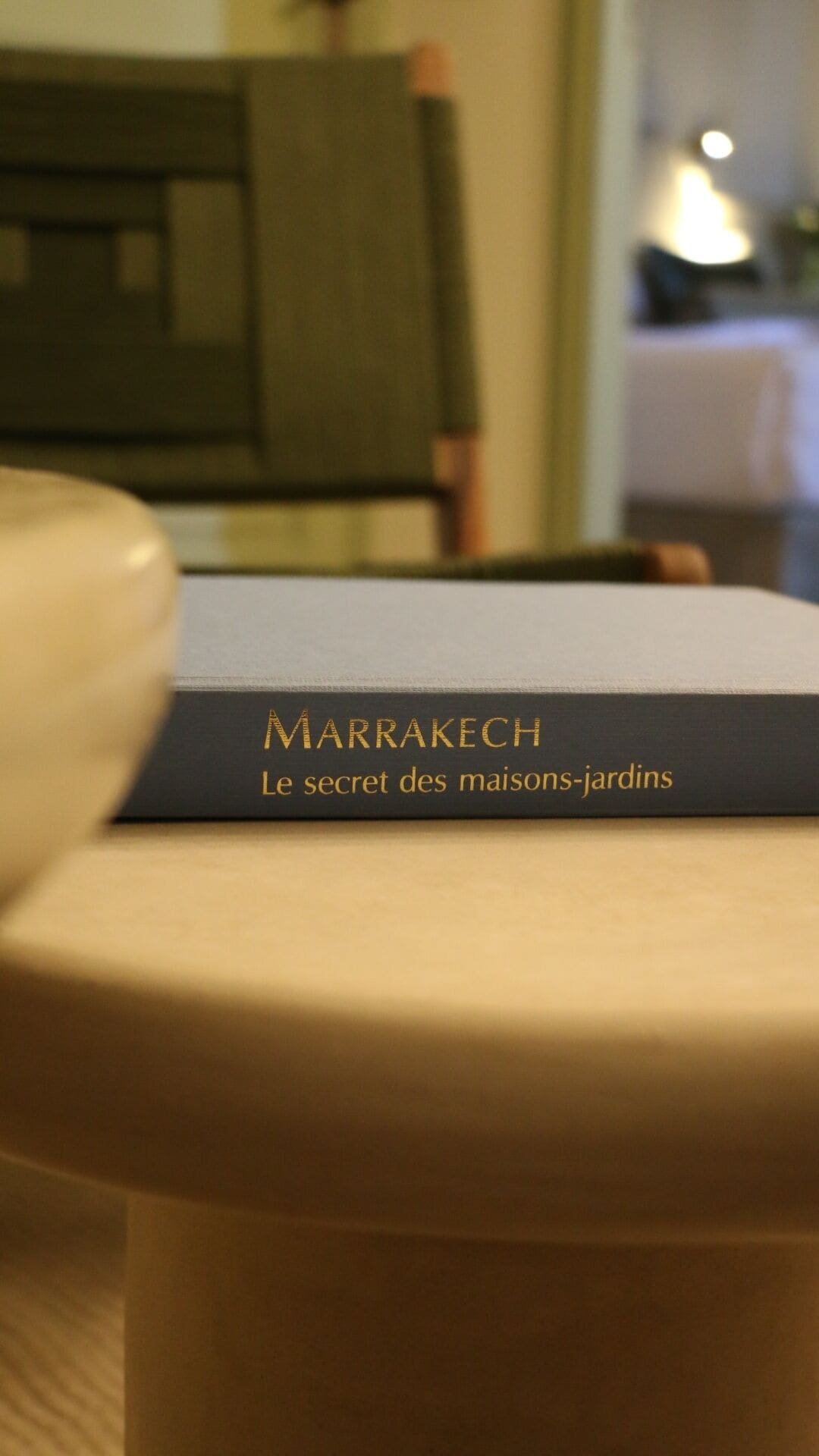 A book titled 'MARRAKECH Le secret des maisons-jardins' on a surface.