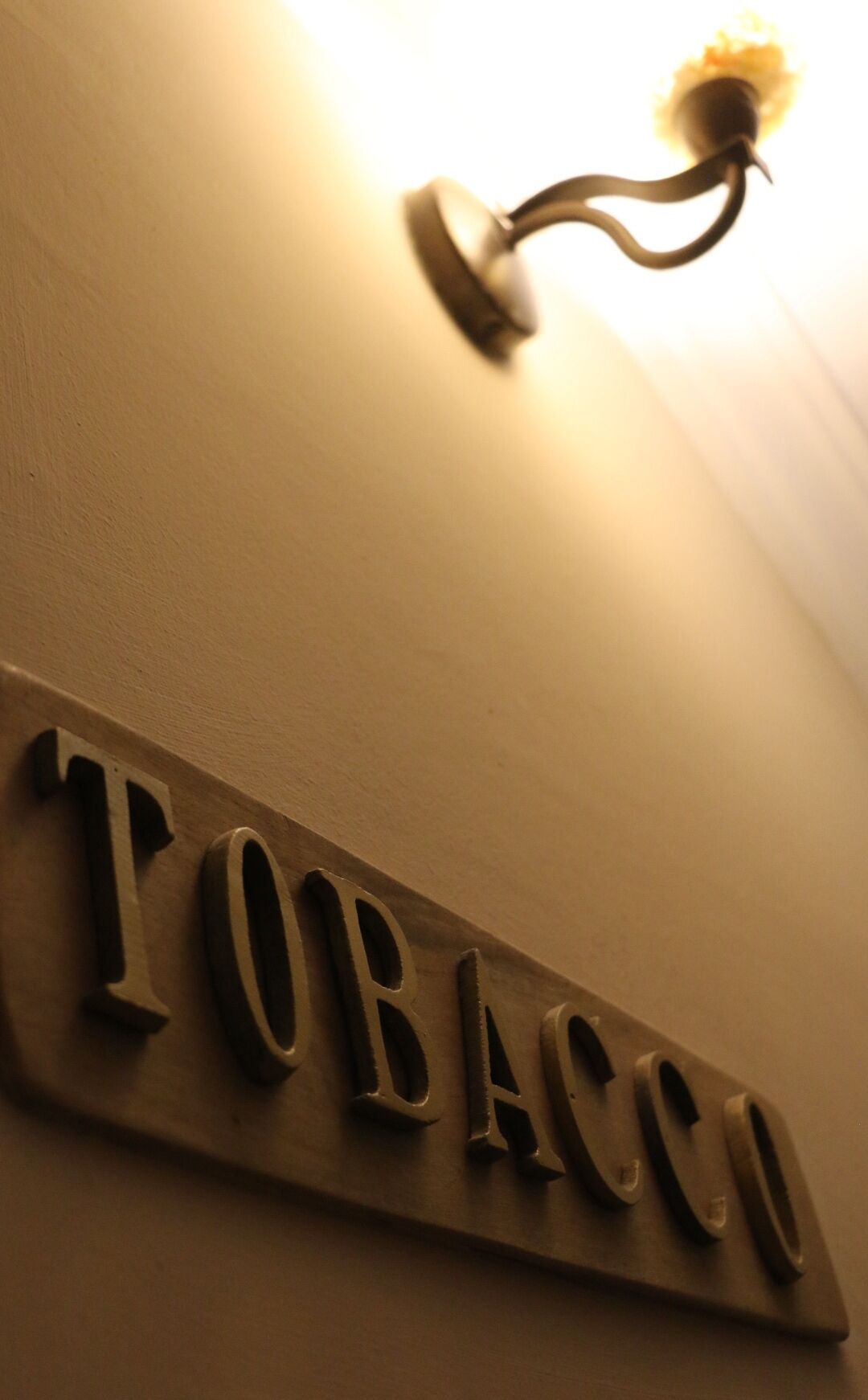 A wall-mounted sign with the word "TOBACCO" in capital letters.