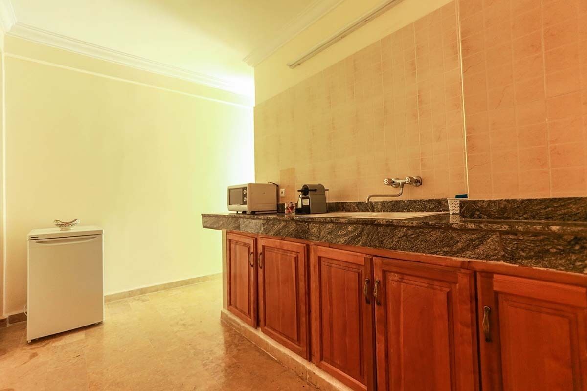 A kitchen with a granite countertop, wooden cabinets, and a built-in oven.