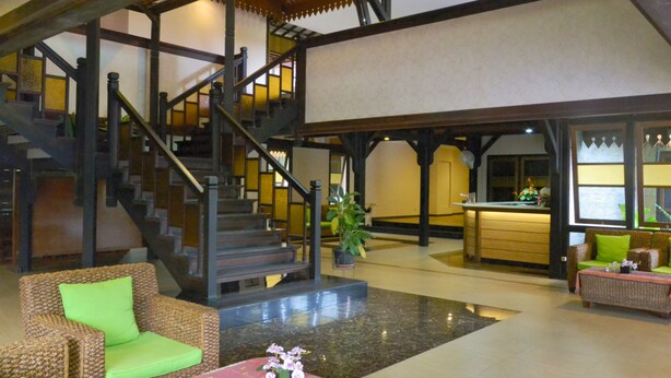 A spacious lobby with a staircase, wicker furniture, and a reception desk. - Arsela Hotel Pangkalan Bun (Pangkalan Bun)