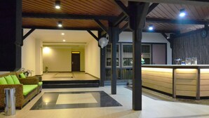 A lobby with a reception desk, a sofa, and a staircase leading to another area. - Arsela Hotel Pangkalan Bun (Pangkalan Bun)