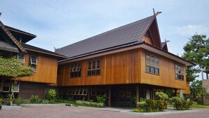 A traditional wooden building with a tiled roof, large windows, and a paved courtyard. - Arsela Hotel Pangkalan Bun (Pangkalan Bun)