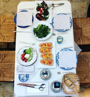 A table set with plates of food, cutlery, and condiments.