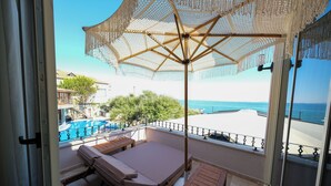 Un balcon avec un lit, une table et un parasol.