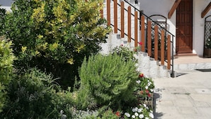 A white building with a wooden staircase and a small porch. - Dal Rosso (San Floriano del Collio)