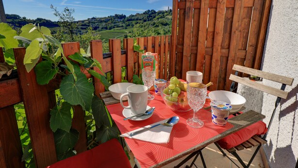A table set outdoors with a scenic view, including a wooden fence and greenery. - Dal Rosso (San Floriano del Collio)