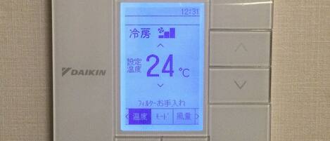 A digital thermostat with a display showing a temperature of 24°C.