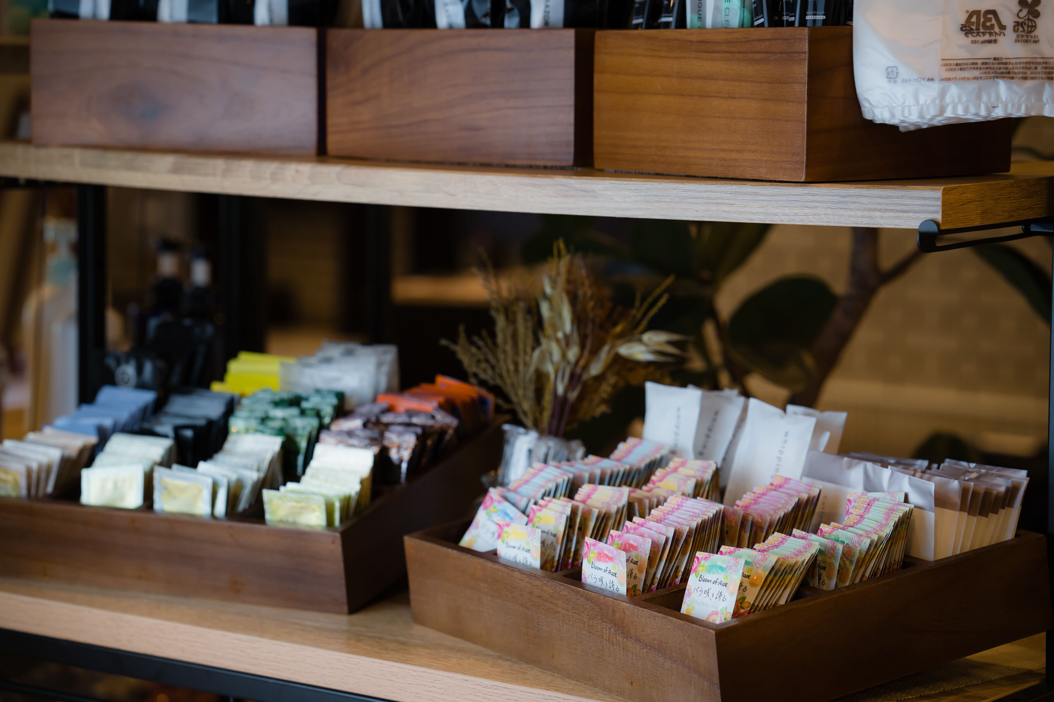 A display of various packaged goods in wooden boxes, with a background of a room containing furniture and decorative items.
