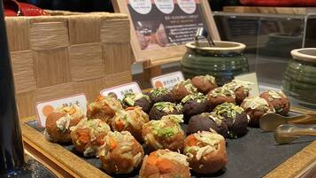 A display of various food items, including Miso and other snacks, arranged on a wooden counter with a sign above.