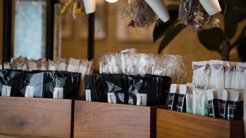 A display of packaged products on wooden shelves, with hanging dried flowers and a light bulb in the background.